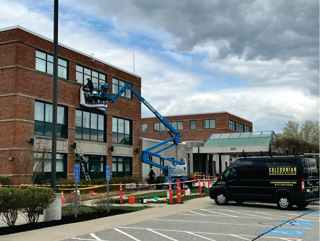 Caledonian Corporation crew and service van on a commercial masonry restoration site in Boston